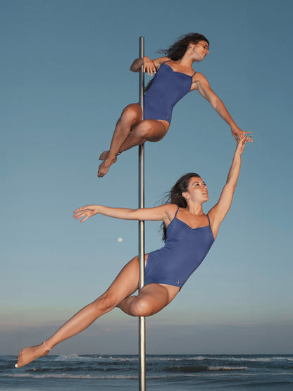 Due donne sul palo in body da pole dance blu con taglio elegante