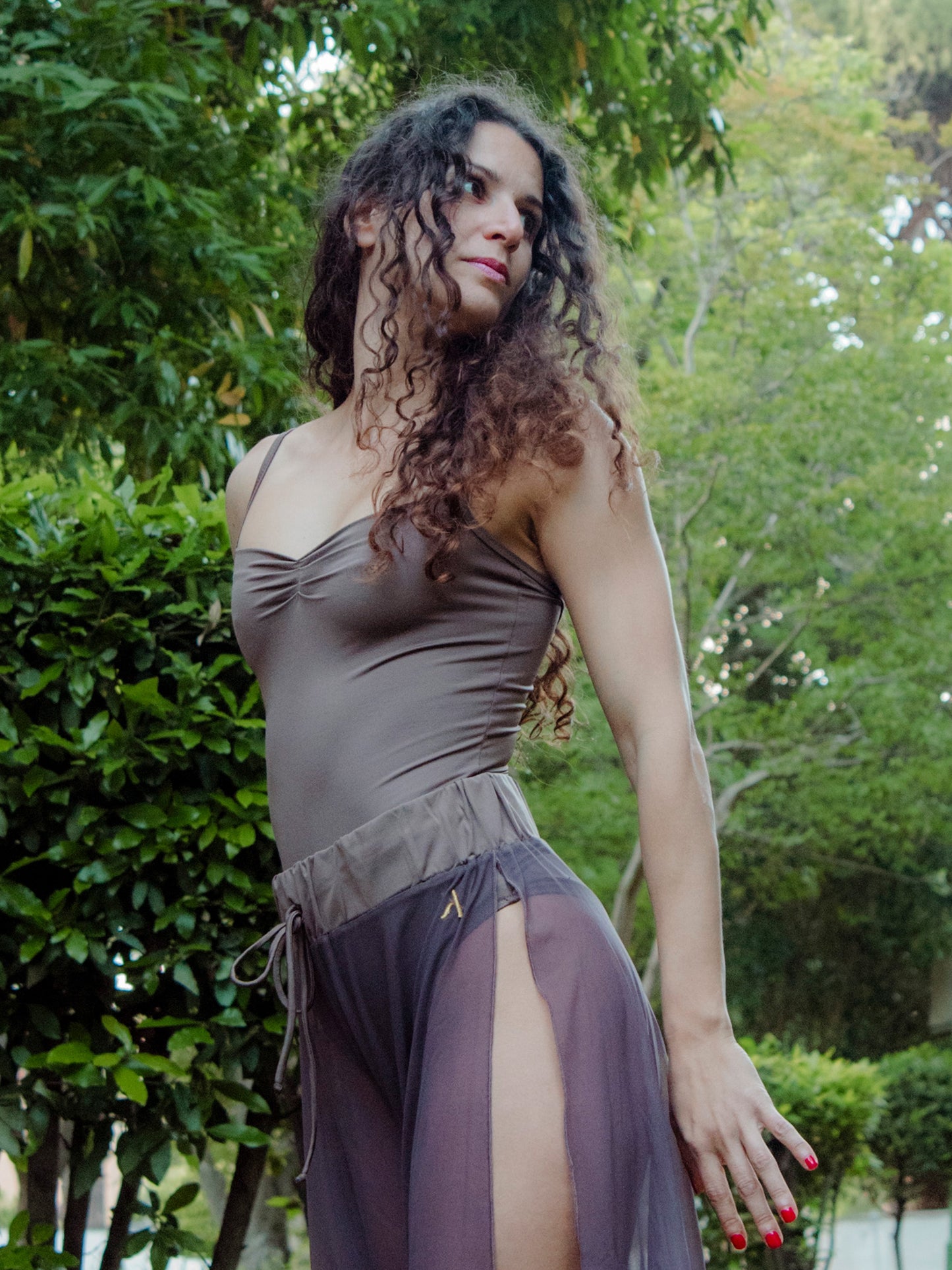 Donna in completo da pole dance marrone, body e pantaloni culotte, con taglio elegante