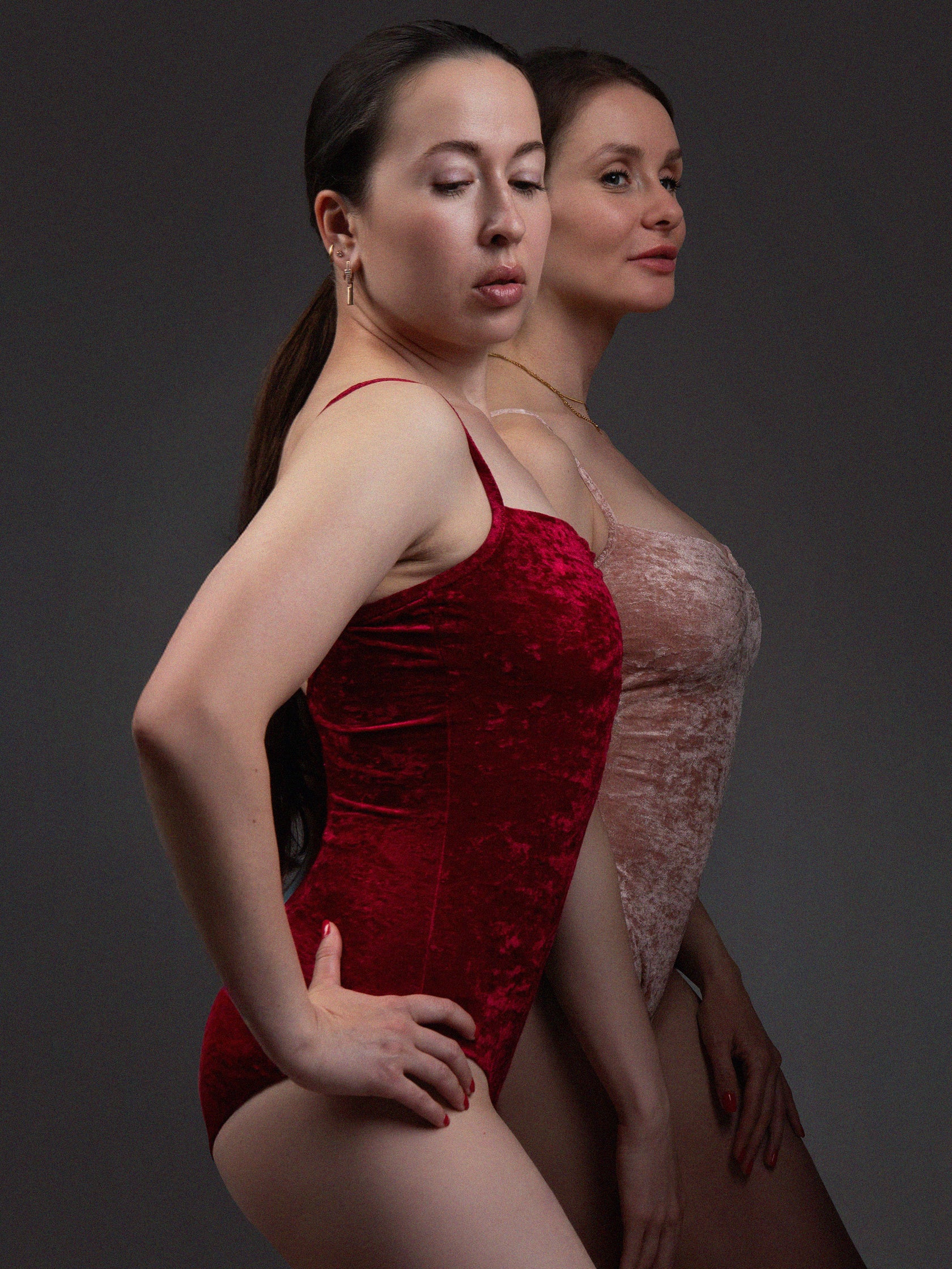 Due donne in body da pole dance in velluto rosso e rosa, stile lusso