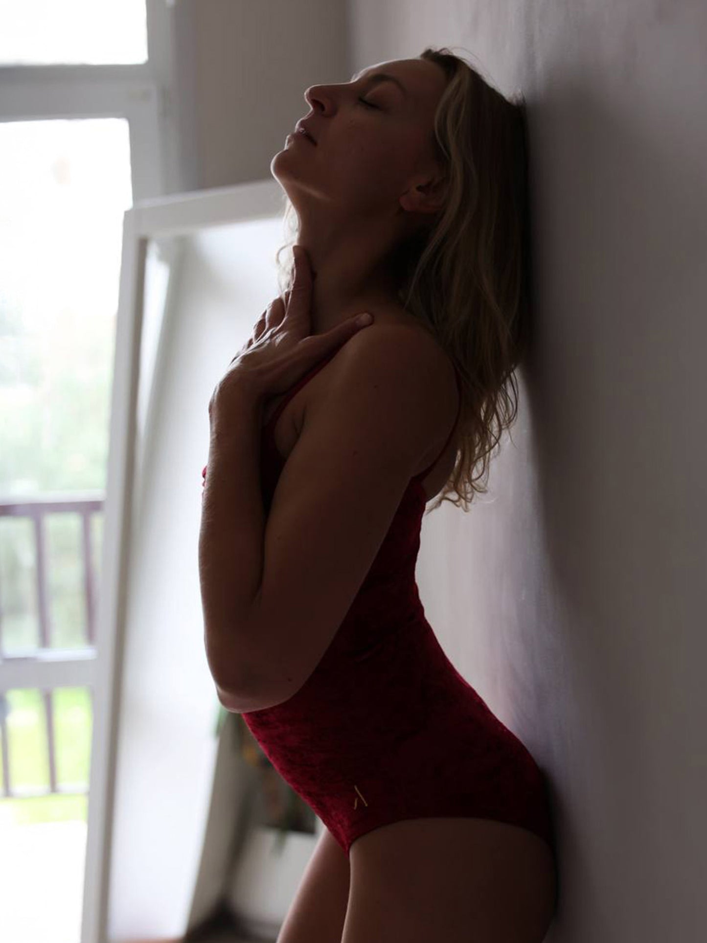 Donna in body da pole dance in velluto rosso, stile lusso