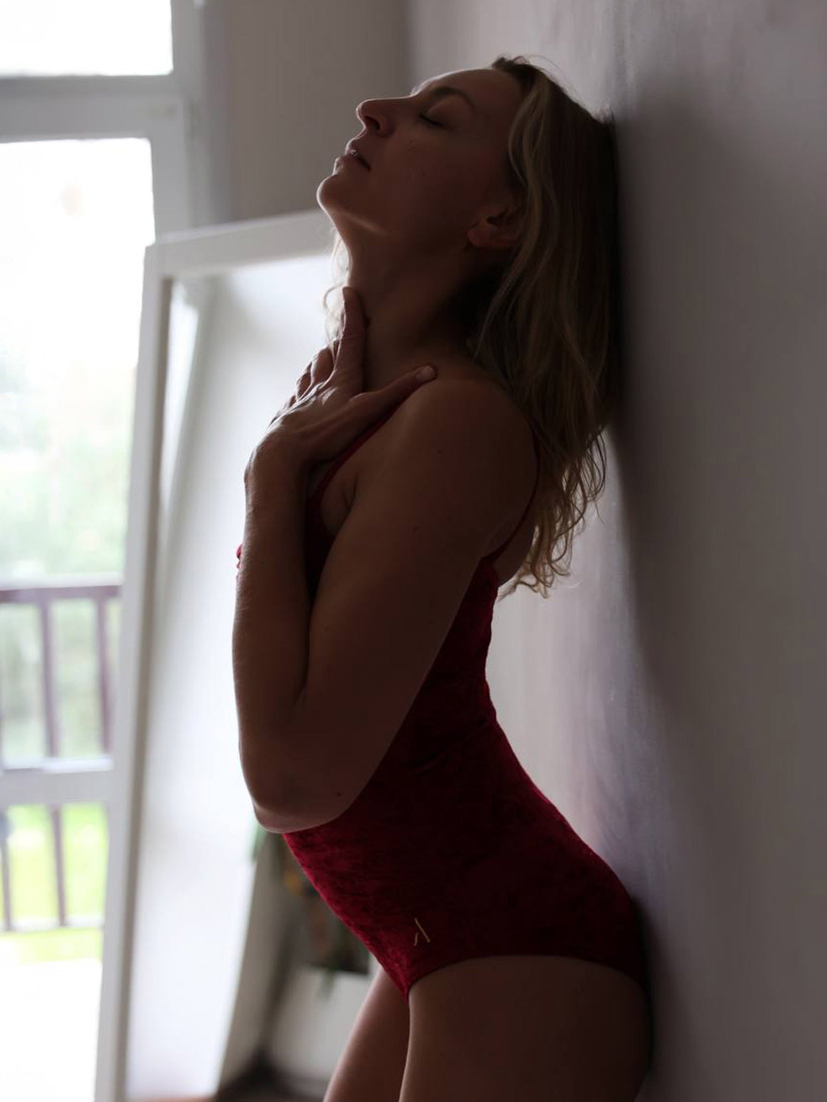 Donna in body da pole dance in velluto rosso, stile lusso