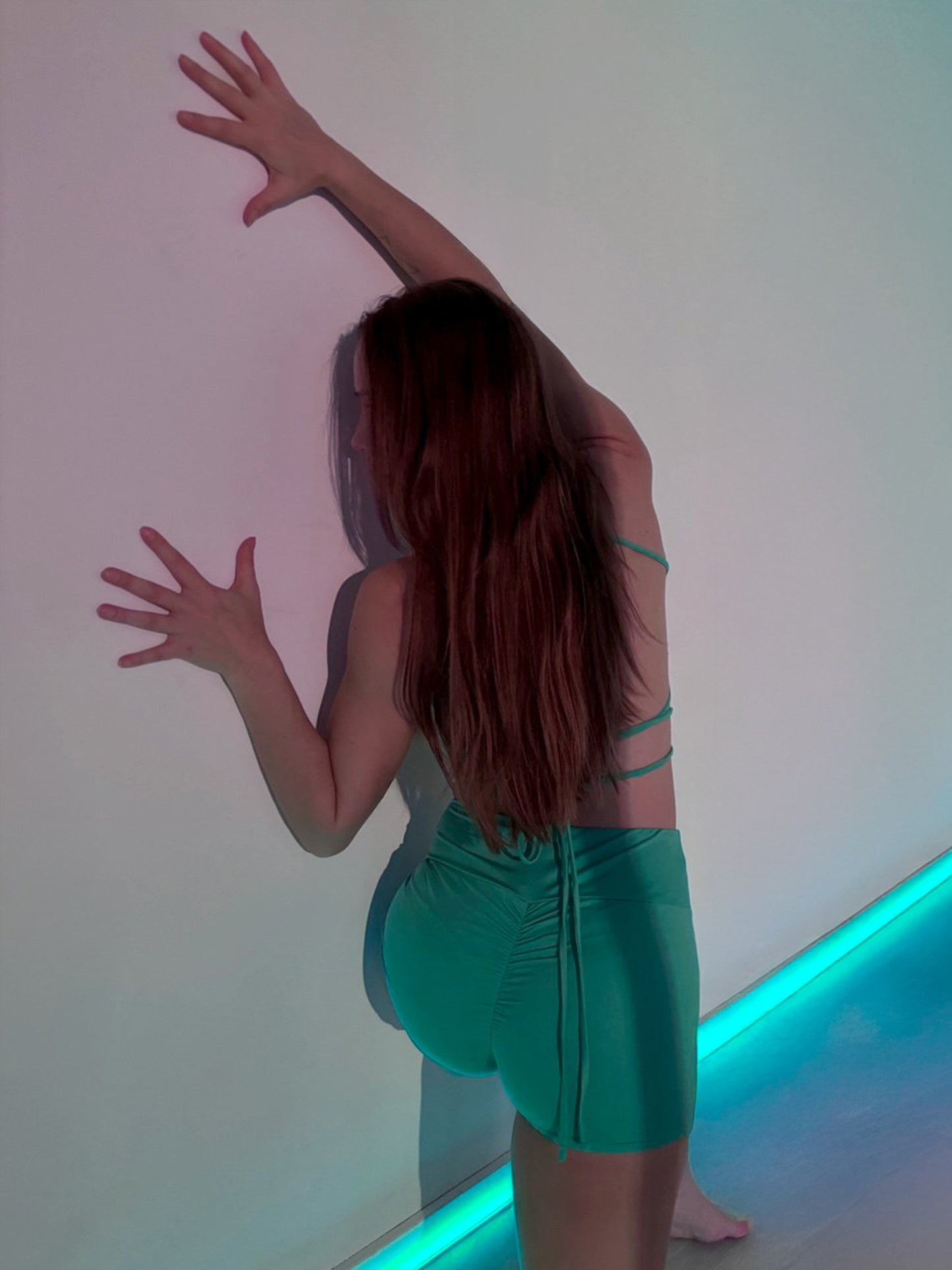 Donna in completo da pole dance verde, top e pantaloncini, stile estate