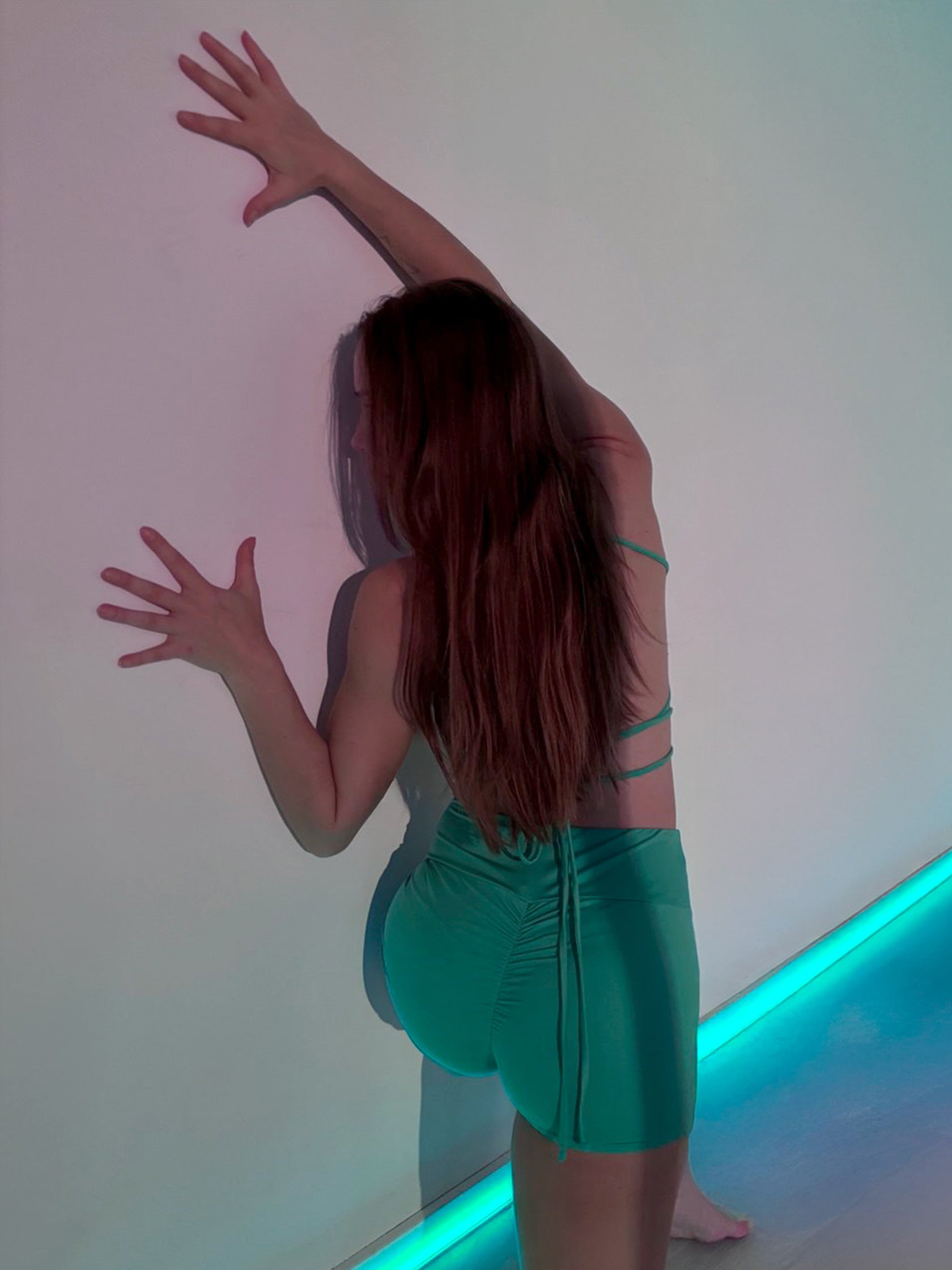 Donna in completo da pole dance verde, top e pantaloncini, stile estate