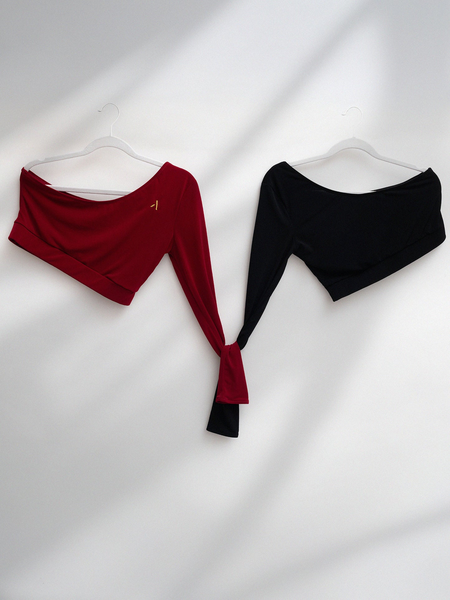 Due top monospalla da pole dance in jersey colori rosso e nero