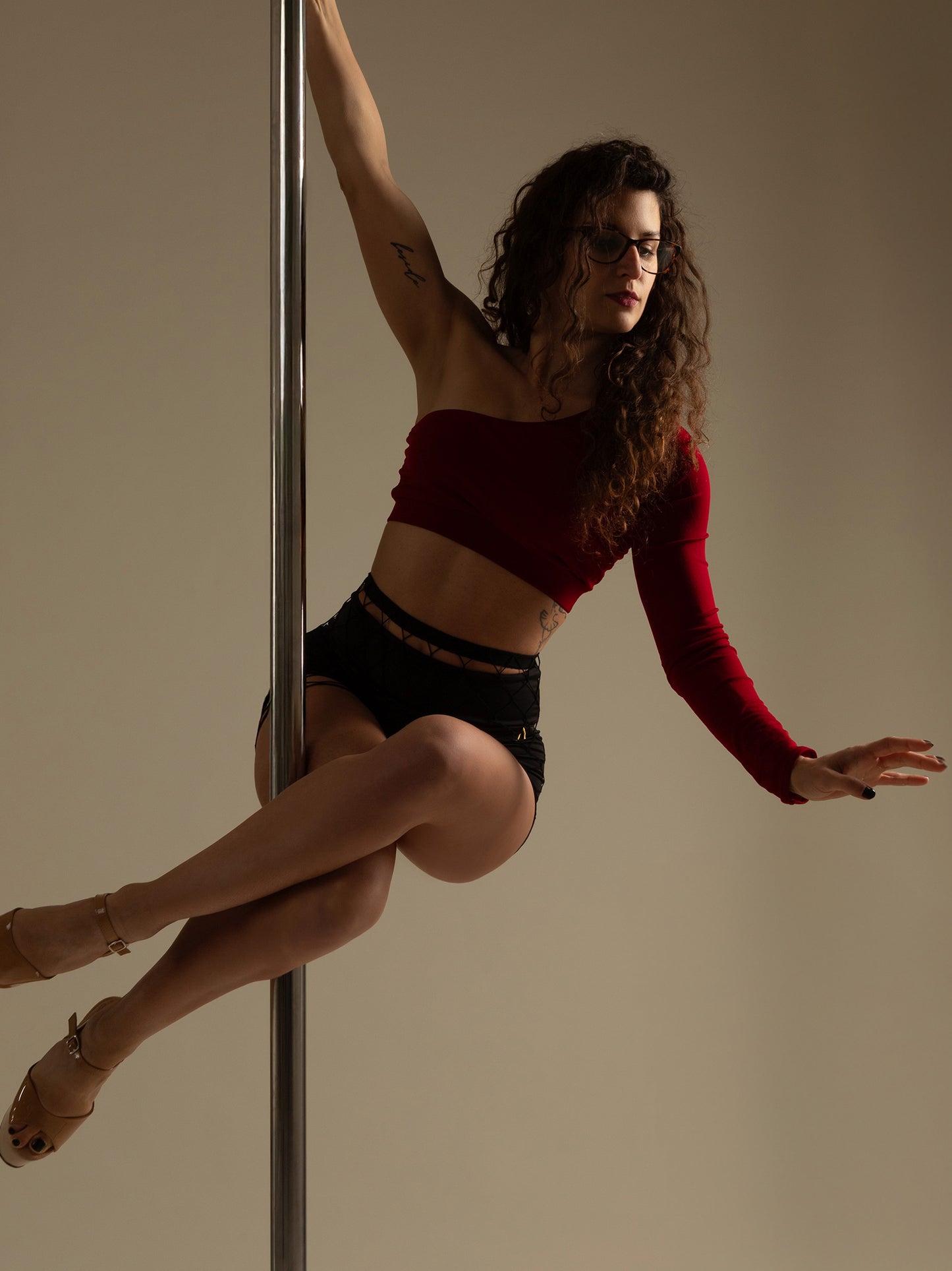 Donna in set da pole dance, top monospalla in jersey color rosso e pantaloni nero