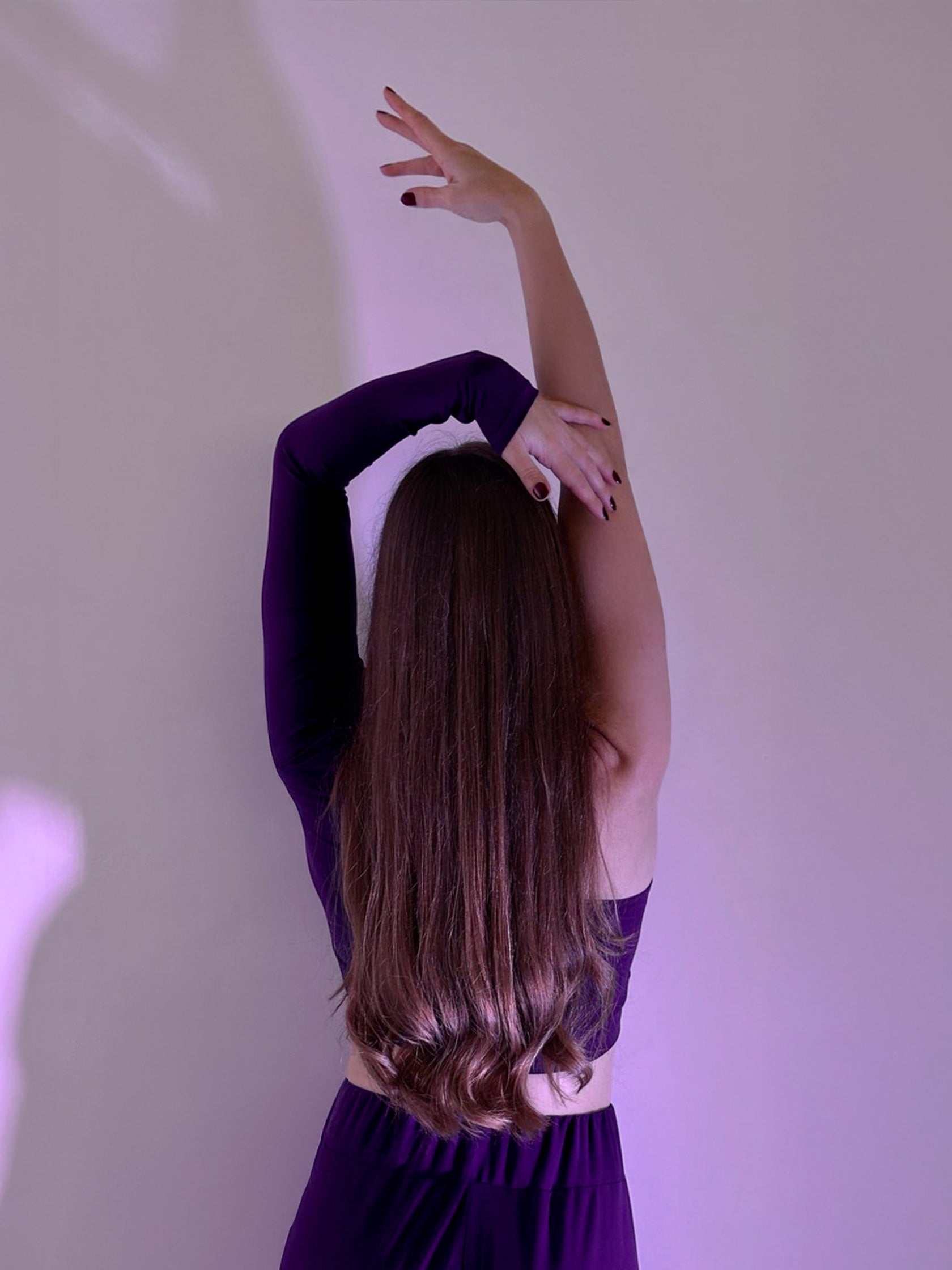 Donna in set da pole dance, top monospalla e pantaloni culotte in jersey color viola