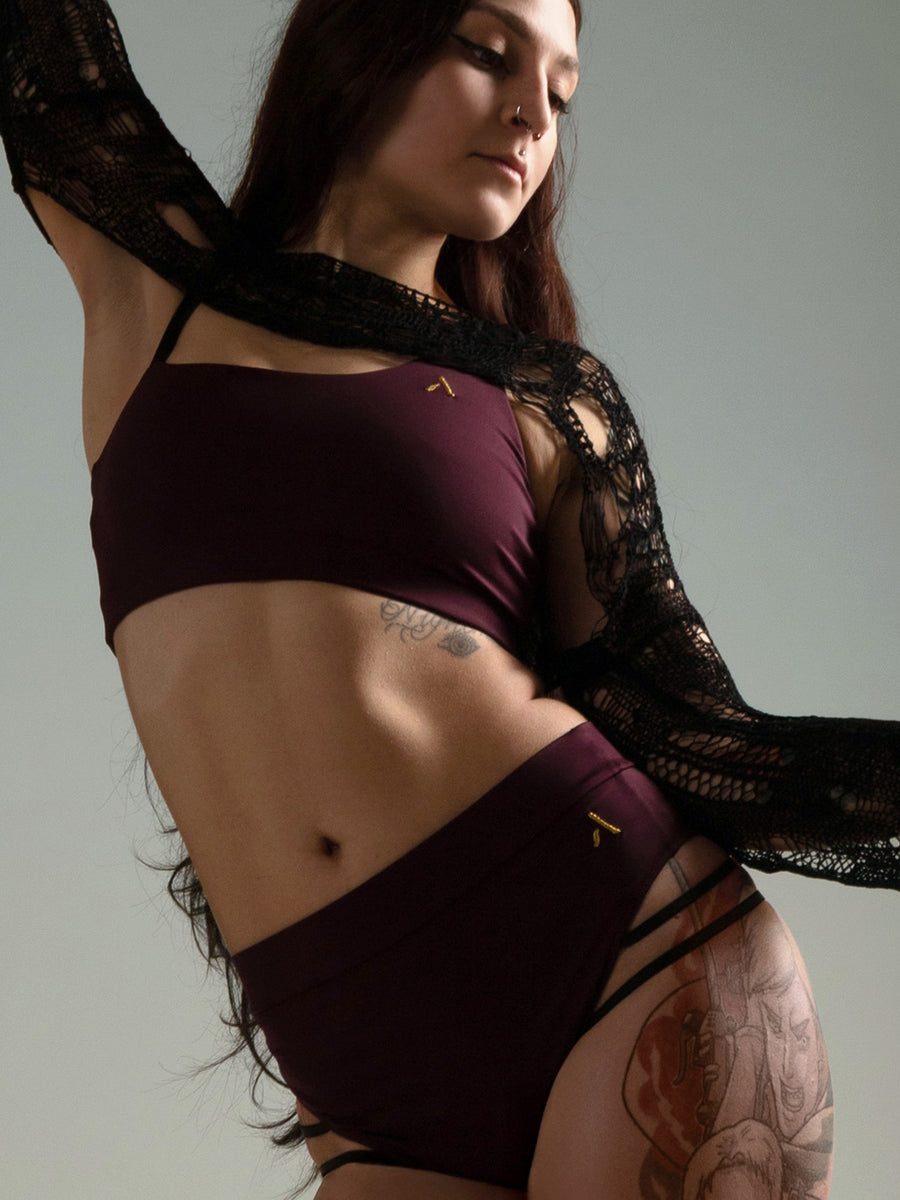 Donna in set da pole dance, top e pantaloncini, color vino