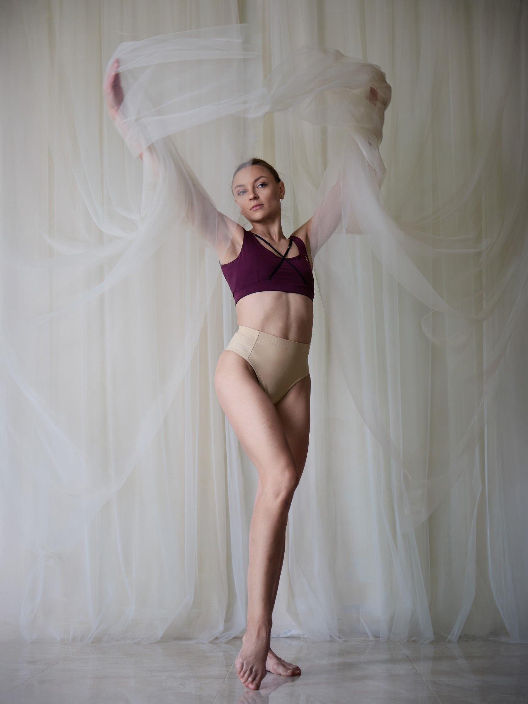 Donna in set da pole dance, top e pantaloncini, color vino