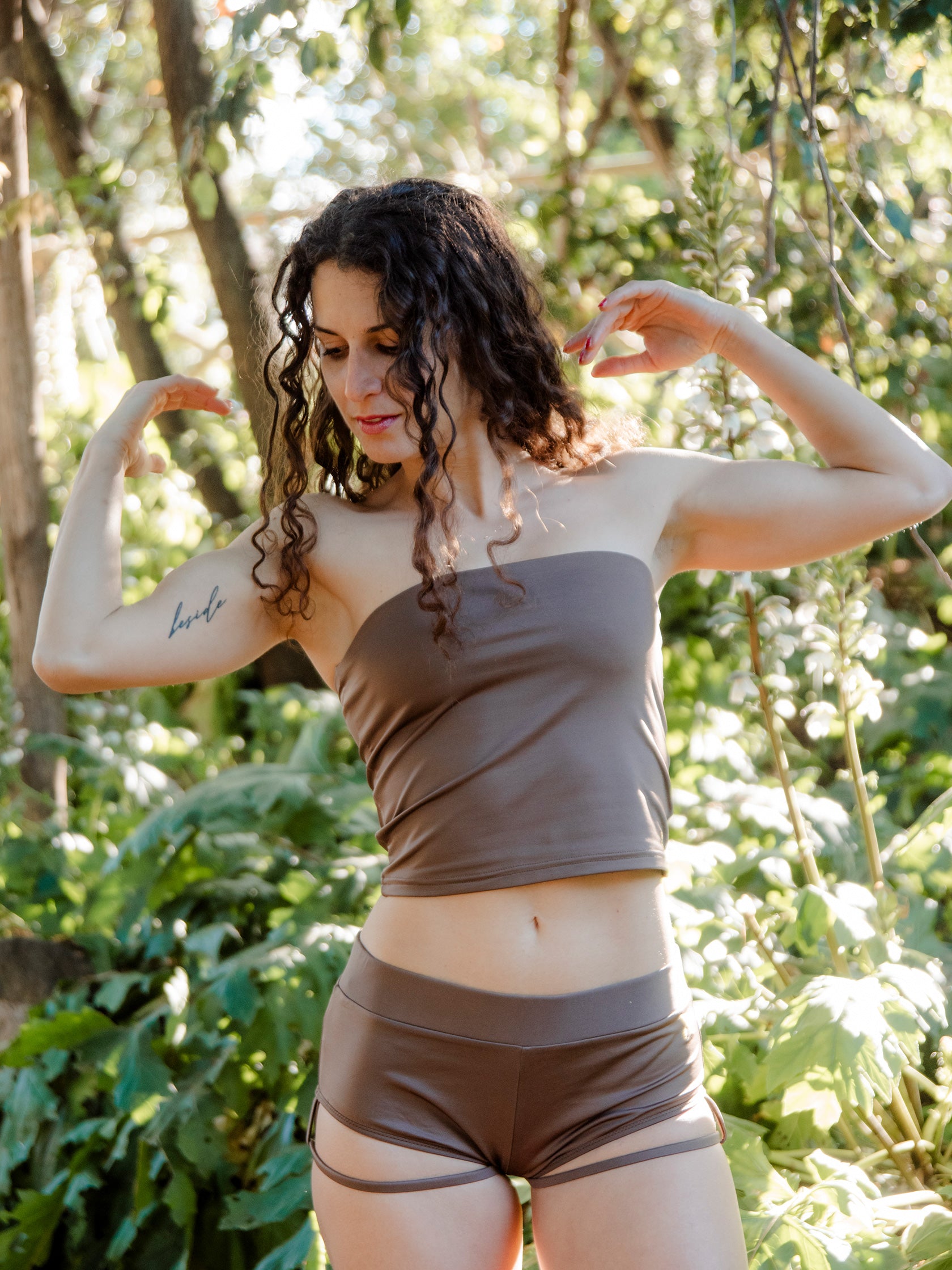 Donna in completo da pole dance marrone, top a fascia e pantaloncini, con cinturini