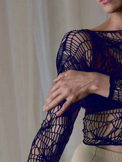 Donna indossa una maglia traforata da pole dance come accessorio, colore blu