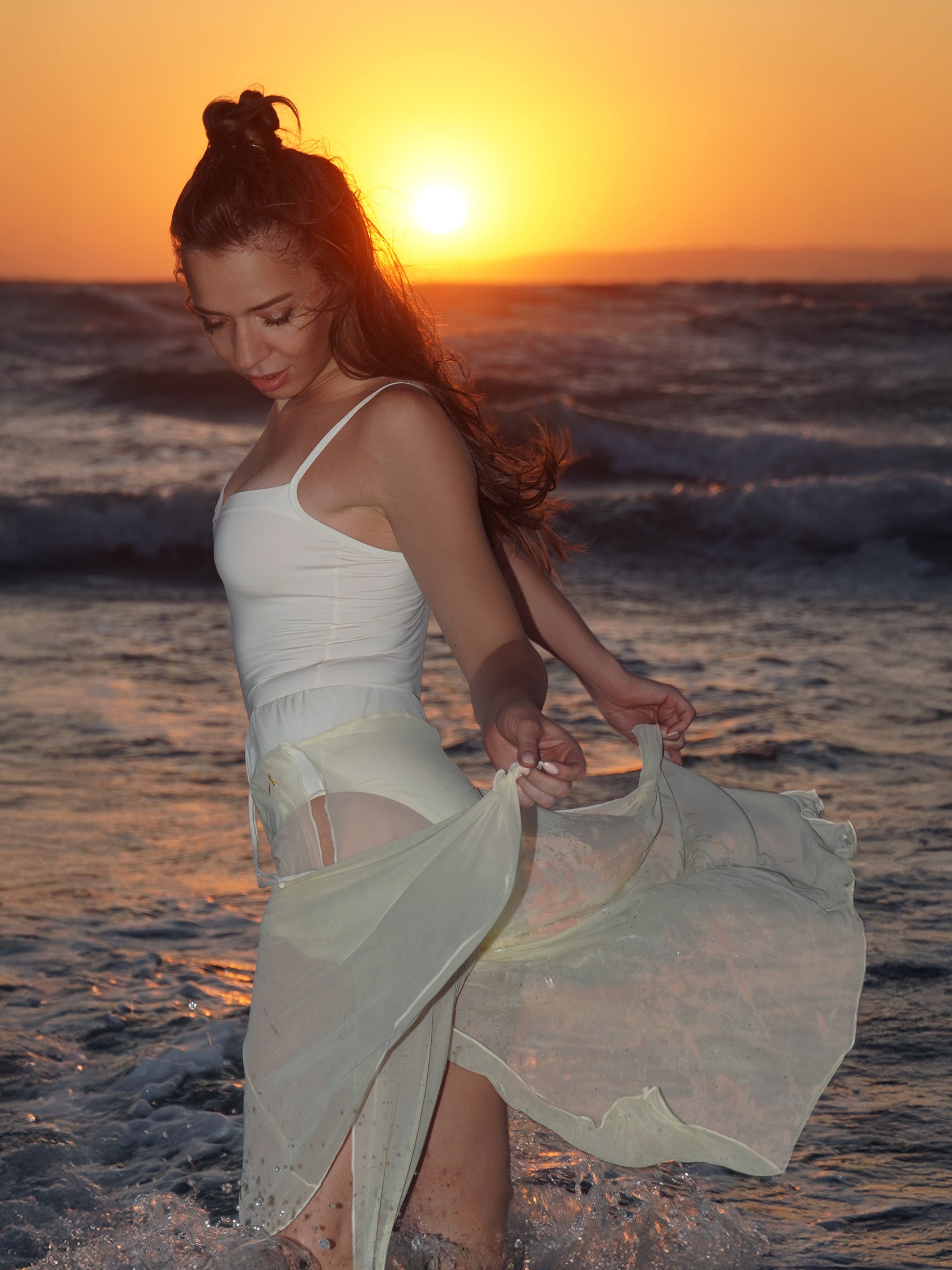 Donna sul palo in completo da pole dance bianco, top a fascia e pantaloni culotte in tulle mesh